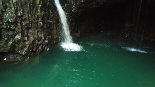 Small waterfall falling from a rocky cliff