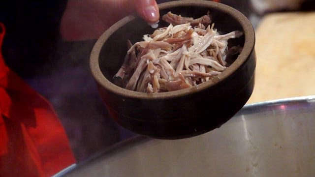Pouring hot broth over bowl a little at a time