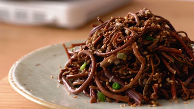 Fern side dish in a ceramic bowl on a wooden table