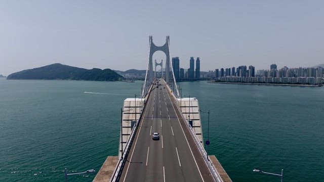 Gwangan Bridge over the blue sea leading to the city skyline of Busan