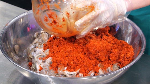 Mixing spicy seasoning with webfoot octopus