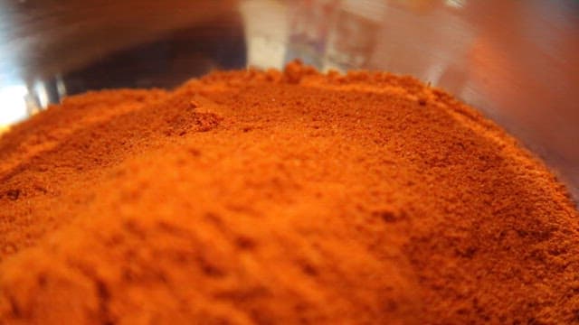A close-up of red chili powder in a bowl