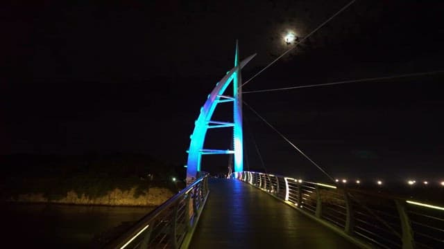 Illuminated Bridge at Night with Moon