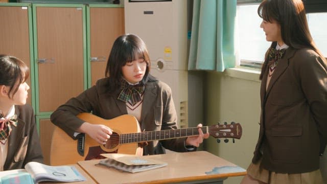 Student playing guitar in a classroom