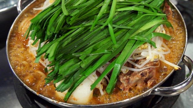 Pork backbone stew topped with chives and bean sprouts