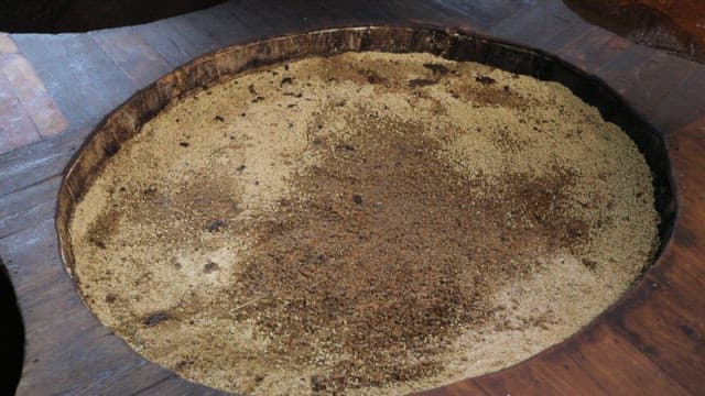 Large wooden vats fermenting food ingredients to make soy sauce