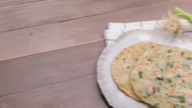 Green onion pancake on a table with green onions