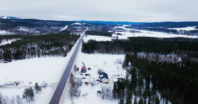 Snow-covered landscape with a long road