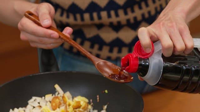 Frying pan with eggs and bamboo shoots drizzled with soy sauce