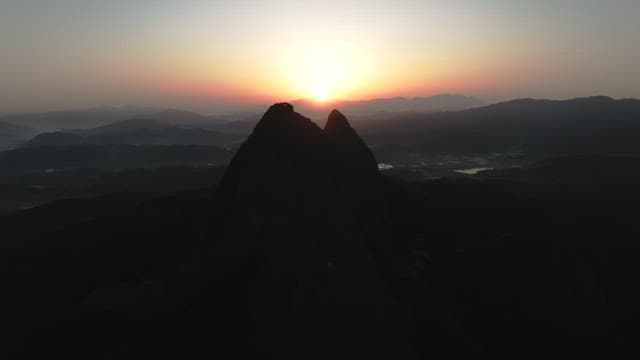 Dawning Sky and Silhouette of Majestic Mountain Peak
