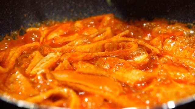 Adding perilla leaves to boiling spicy tteokbokki