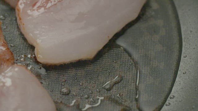 Pork belly sizzling on a hot pan