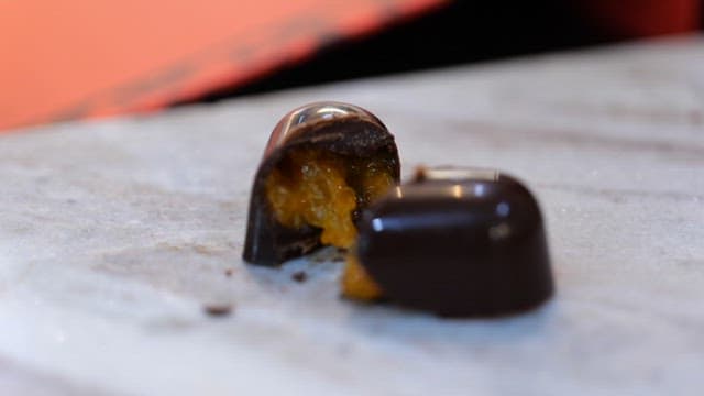 Dark chocolate with orange filling on a marble surface