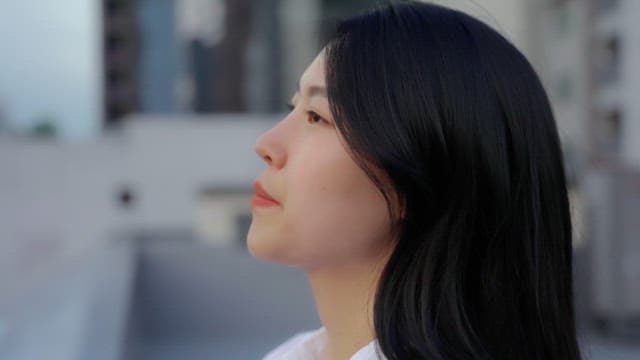 Woman looking at the city from a balcony