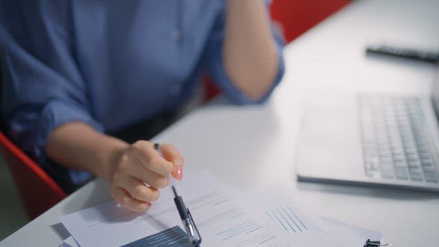 Hands worrying at a desk with documents on it