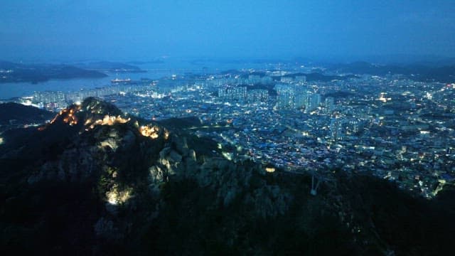 Cityscape with illuminated mountains at dusk