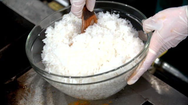 Mixing rice and bean sprouts in a pot