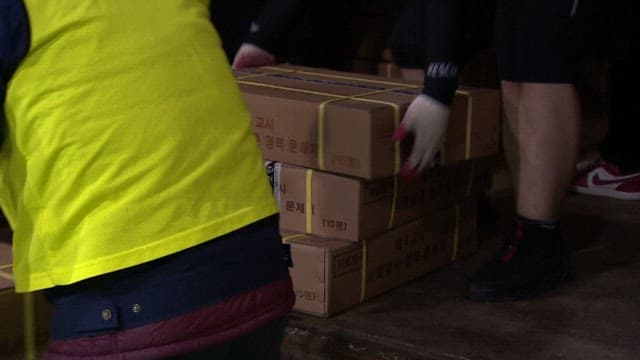 People Moving Boxes of Packed CSAT Question Papers