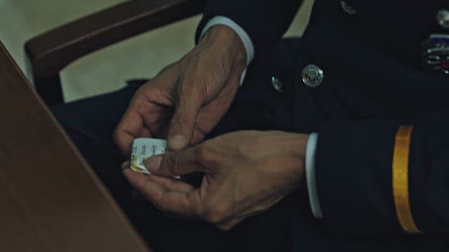 Police Officer Putting Folded Paper Crane It on the Table