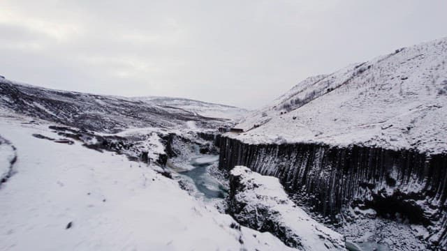 Snow-covered canyon with a flowing river