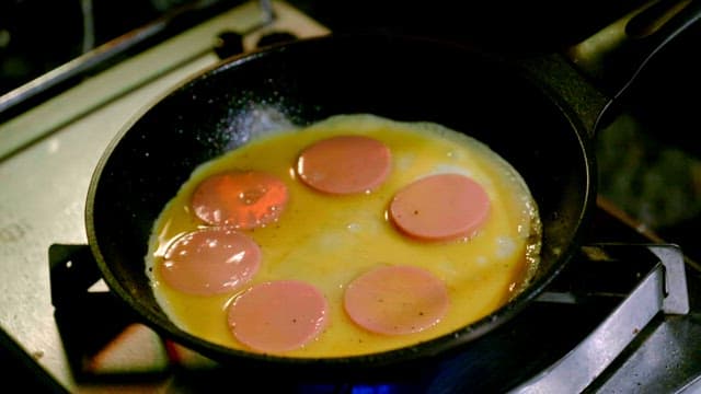 Egg and sausage cooking in a pan