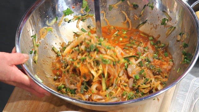 Putting cold raw fish soup in a bowl with ice