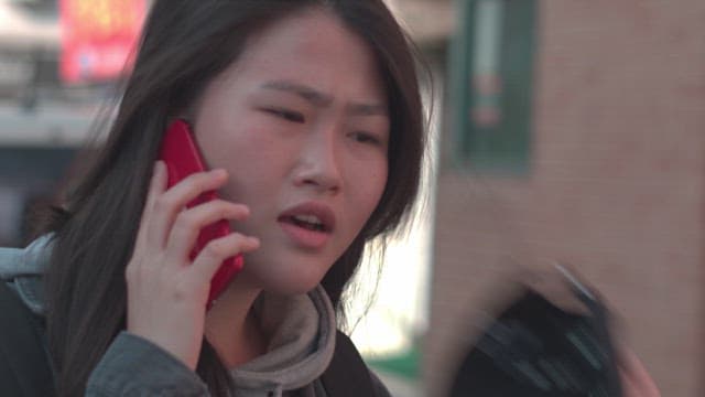Woman talking on the phone with a serious expression during the day