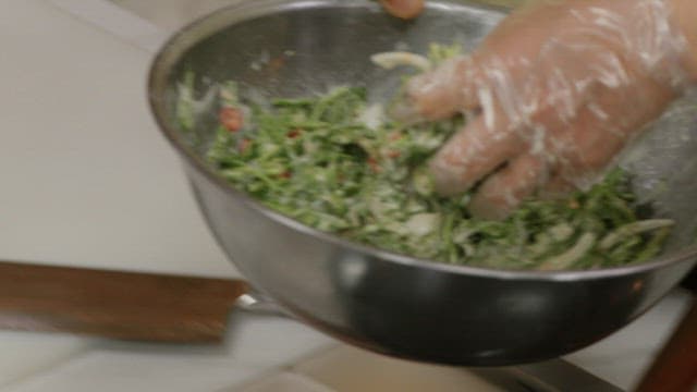 Placing the batter of the water parsley pancake on an oiled frying pan