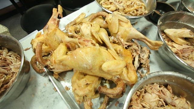 Group of people preparing a huge chicken