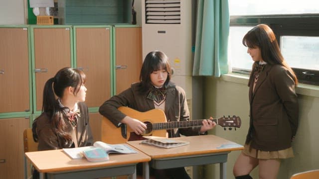 Student playing guitar in a classroom