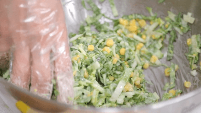Fresh spring cabbage coleslaw with corn mixed with dressing