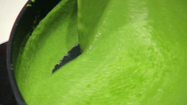 Green batter being stirred in a pan