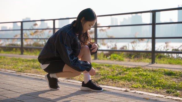 Woman tying shoelaces on a sunny day