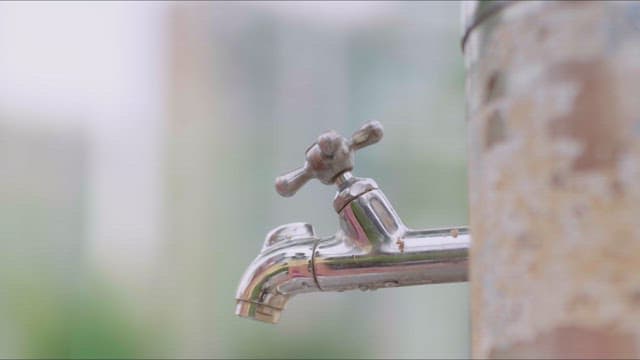 Girl making eye contact with a boy while drinking water from the tap