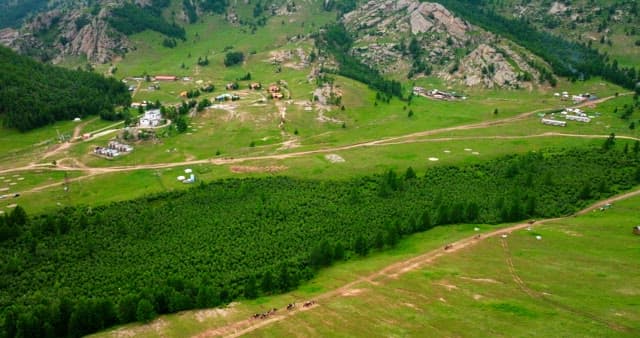 Expansive green landscape with distant village