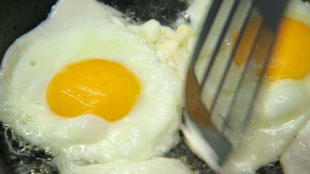 Frying eggs in a pan with a spatula