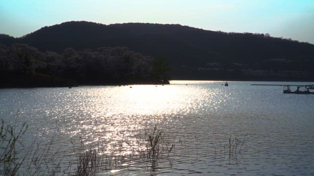 Lake view surrounded by mountains and sparkling in the sunlight
