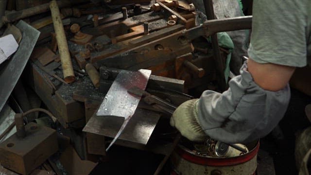 Worker shaping metal in a factory