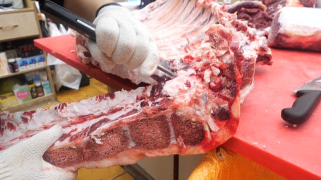 Butcher skillfully cuts and prepares raw meat