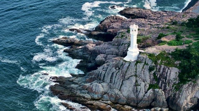 White Lighthouse on the Sea Rock Cliff