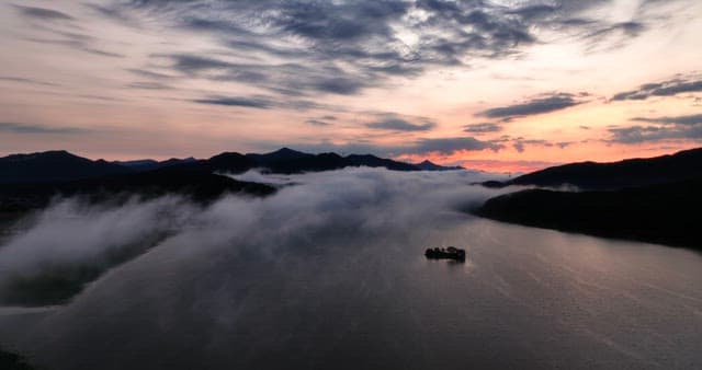 Serene river with misty mountains at dawn
