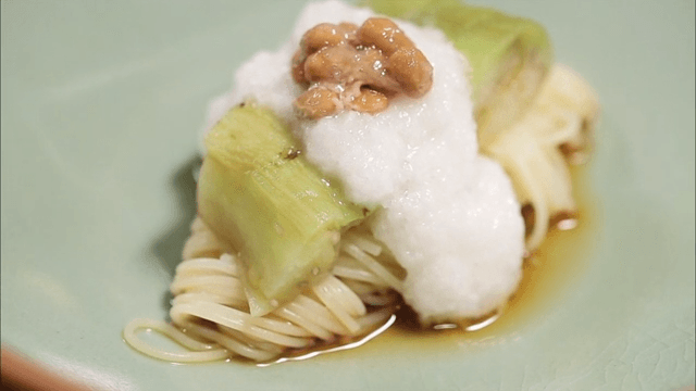 Bowl of buckwheat soba topped with natto and grilled eggplant