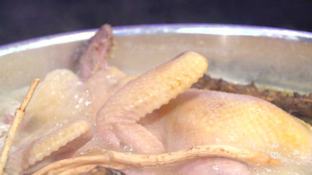 Chicken hotpot with various ingredients boiling in a cauldron