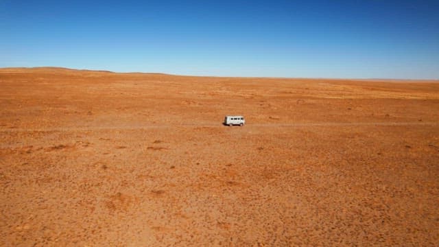 Van traveling across a remote desert landscape