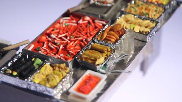 Diorama depicting a street food stall with a variety of food