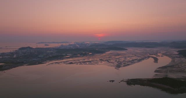 Sunset over a calm sea with distant mountain