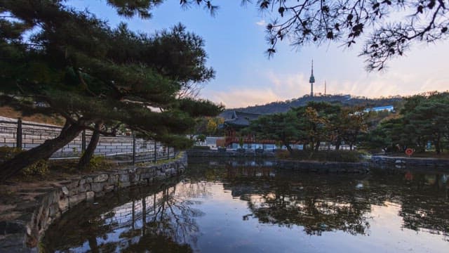 Pond at dusk with a traditional Korean pavilion in the background