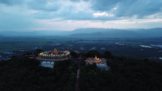 Magnificent temple on top of Mandalay Hill surrounded by nature at dusk