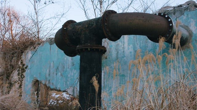 Rusty pipeline on a Barren Background with Dry Grass