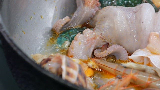 Various seafood such as octopus and abalone boiling in a pot